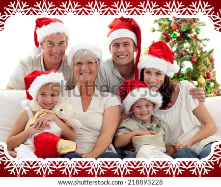 Children sitting with their family holding Christmas boots against snowflake frame