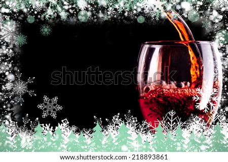 Composite image of snow frame against stemware being filled with wine