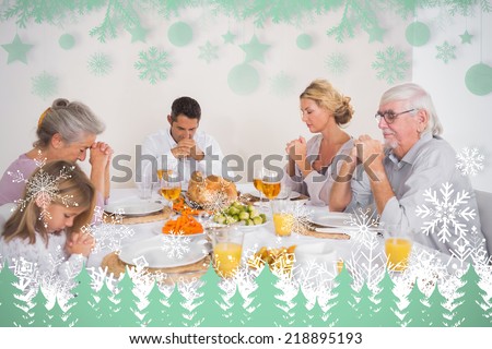 Family saying grace before eating a turkey against snowflakes and fir trees in green