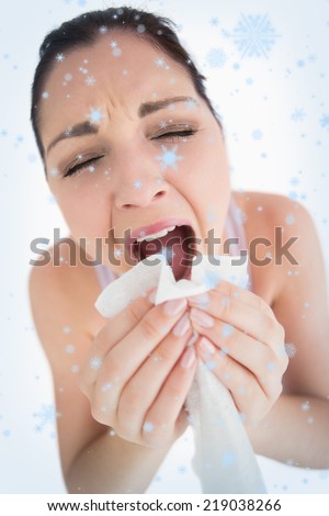 Woman sneezing into a tissue against snow falling