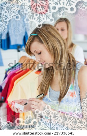 Happy women choosing clothes together with snowflakes on silver