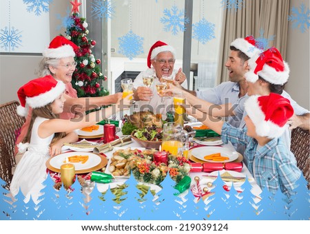 Family in santas hats toasting wine glasses at dining table against snowflakes and fir trees in blue