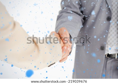 People in suit shaking hands against snow falling