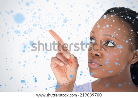 Close up of woman pointing at something next to her on a white background against snow falling