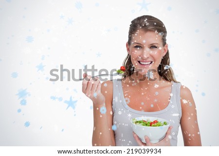 Composite image of woman eating a salad against snow falling