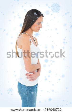 Casual woman with stomach pain and headache against snow falling