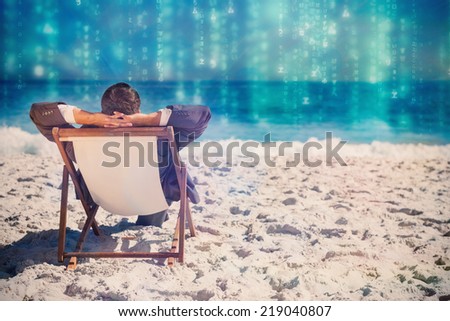 Young businessman relaxing on his sun lounger against lines of green blurred letters falling