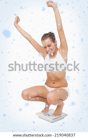 Composite image of Happy attractive woman crouching on a scales with snow falling