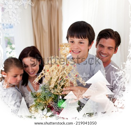Smiling family decorating a Christmas tree at home against christmas frame