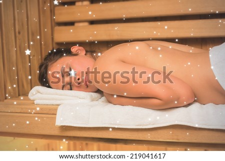 Calm brunette lying down in a sauna against snow