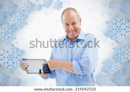 Happy mature man pointing to his tablet pc against snowflake frame