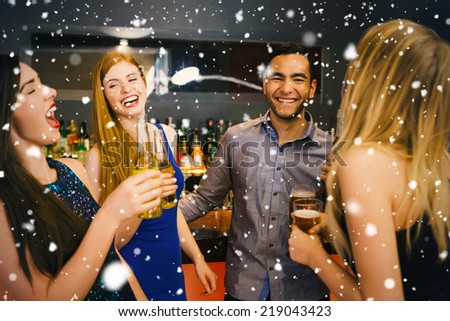 Composite image of Laughing friends drinking beers against snow falling