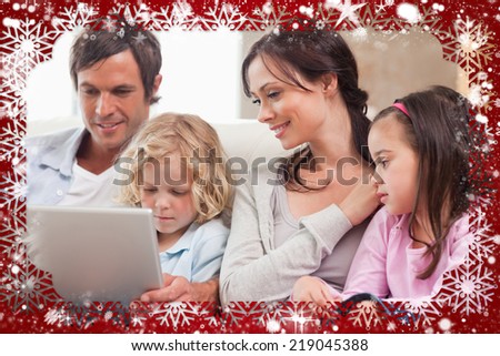 Composite image of serene family using a notebook against snow