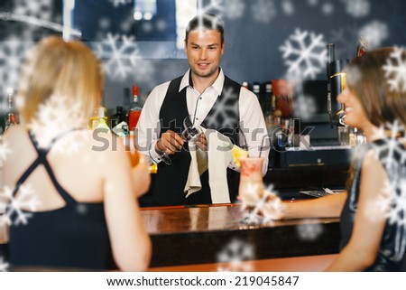 Handsome bartender working while gorgeous friends speaking against snowflakes