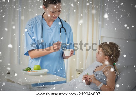 Composite image of doctor feeding meal to sick girl against snow falling