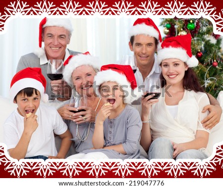 Family drinking wine and eating sweets in Christmas against snowflake frame