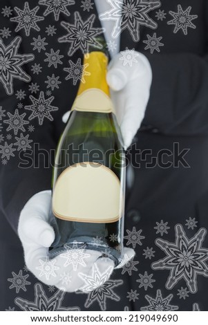 Close view of open bottle of champagne against snowflakes on silver