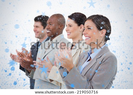 Side view of clapping sales team standing together against snow falling