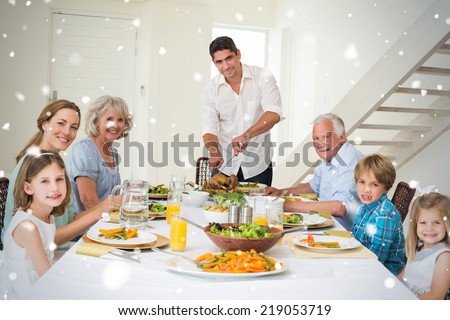 Composite image of Smiling father serving meal to family against snow falling