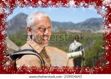 Hiking couple walking on mountain trail man smiling at camera against snow