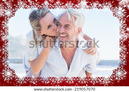 Man giving his smiling wife a piggy back at the beach against snow
