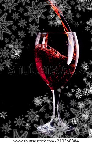 Snowflakes on silver revealing red wine being poured into glass