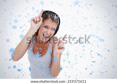 Woman dancing while listening to music against snow falling