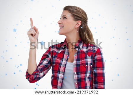 Smiling woman pointing at a copy space against snow falling