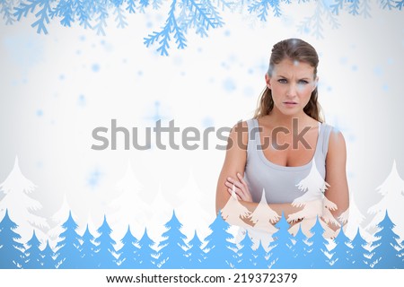 Unhappy woman with the arms crossed against frost and fir trees