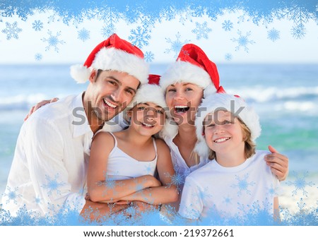 Family during Christmas day at the beach against snow flake frame in blue