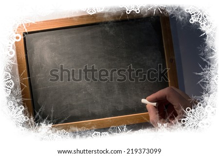 Composite image of frost frame against hand holding chalk over chalkboard