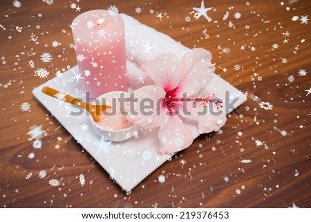 Composite image of snow against spa objects on wooden floor