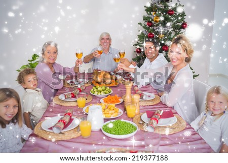 Composite image of Family raising their glasses at christmas against snow falling