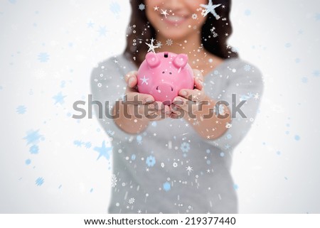 Piggy bank being held by woman against snow falling