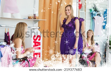 Composite image of a Delighted women choosing clothes together against snow