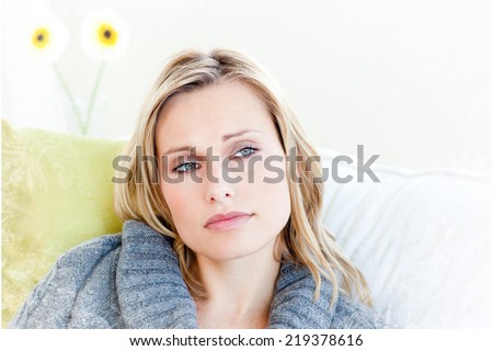 Exhausted woman lying on the sofa with a grey pullover against frost