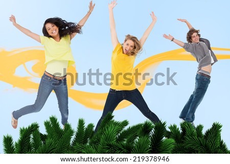 Attractive young man and women jumping for joy against digitally generated fir tree branches