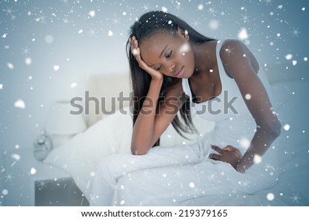 Composite image of woman having a headache against snow falling