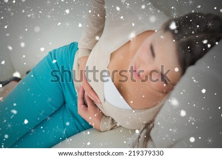 Composite image of ill women lying on the sofa against snow falling