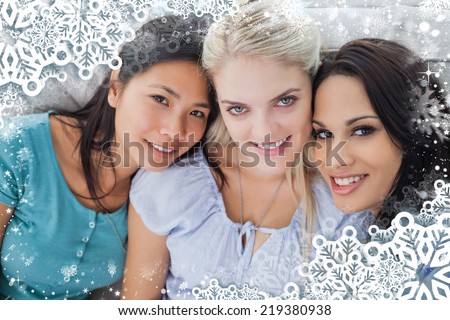 Composite image of snow frame against close friends smiling at camera