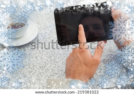 Businessman using small tablet at table against snow