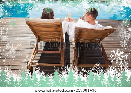 Couple toasting champagne by swimming pool against snow