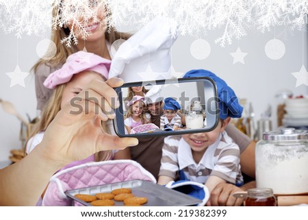 Hand holding smartphone showing photo against hanging decorations