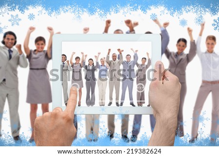 Hand holding tablet pc against snow flake frame in blue
