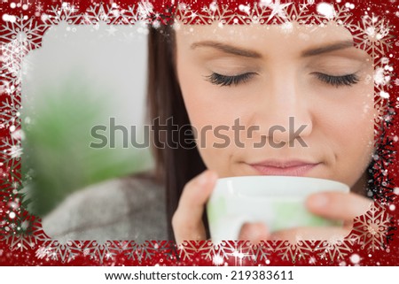 Composite image of girl holding a cup of coffee against snow
