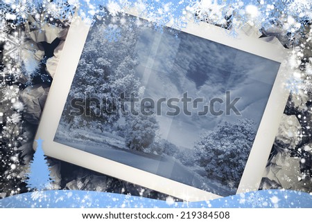 Composite image of tablet screen against snow flake frame in blue