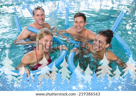 Happy fitness class doing aqua aerobics with foam rollers against snow