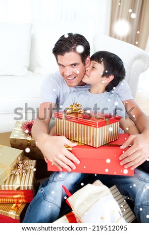 Composite image of Son kissing his father after receiving a Christmas gift with snow falling