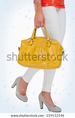 Composite image of Woman in high heels walking with yellow bag with twinkling stars