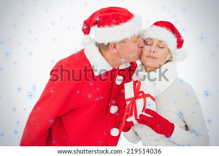 Festive couple smiling and holding gift against twinkling stars